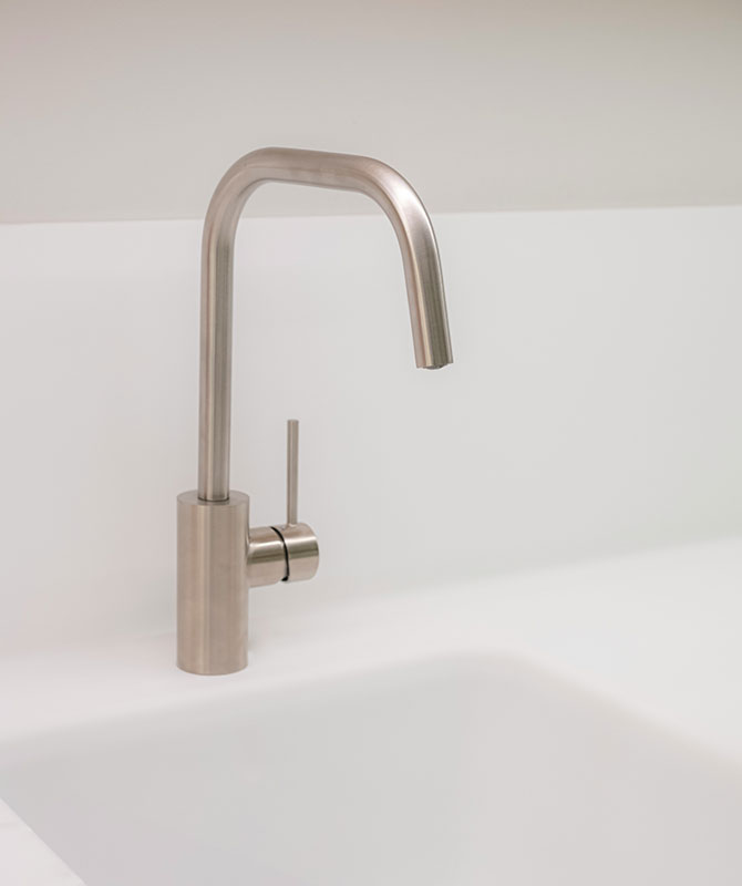 Brass faucet installed on a white sink
